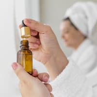 Frau hält Körperöl nach dem Duschen