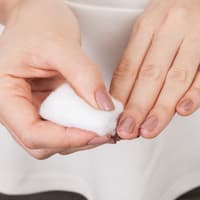 Nagellack von den Fingernägeln mit einem Wattepad entfernen