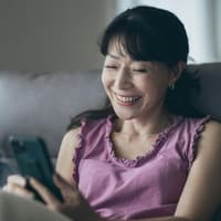 Welche Faktoren unser Online-Datinglück bestimmen, liest du hier. Frau lächelt in ihr Handy