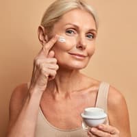 Frau trägt Creme aufs Gesicht