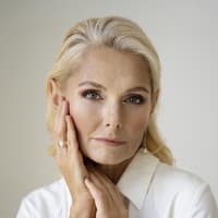 Frau fasst sich ins Gesicht