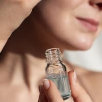 Frau trägt Hautpflege-Serum auf