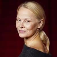 Pamela Anderson guckt über die Schulter nach hinten.