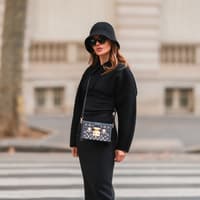 Wie vielfältig du ein schwarzes Kleid kombinieren kannst, erfährst du hier. Frau trägt schwarzes Kleid