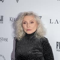 Debbie Harry mit einem schwarzen, hoch geschlossenen Kleid mit Glitzersteinen.