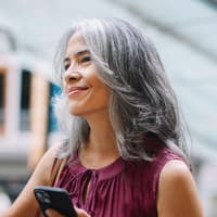 Graue Haare pflegen, ohne Glanz zu verlieren, ist gar nicht so einfach. Eine Frau mit schulterlangen, gestuften und grauen Haaren.