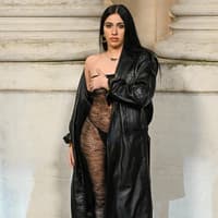 Lourdes Leon in einem transparenten Kleid mit Leder-Trenchcoat.