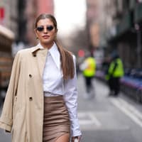 Frau trägt einen beigefarbenen Trenchcoat