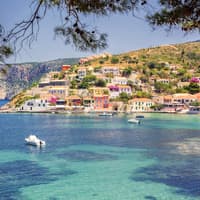 Die Küste von Kefalonia mit bunten Häusern und Booten auf dem Wasser.