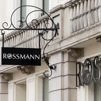 Jetzt reduziert: Dieses Sonnenfluid schützt und pflegt zugleich. Rossmann Filiale von draußen mit schwarzer Schrift und schwarzem Logo.