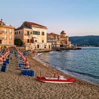 Strand von Cilento mit Häusern, Liegen und Sonnenschirmen.