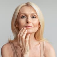 Mit welchem einfache Hautpflegeprodukt wir unsere Lippen aufpolstern können, verrät ein Dermatologe. Frau fässt ihre Lippen an