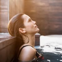 Im Pool kommen viele zur Ruhe und können entspannen. Frau von der Seite liegt im Pool und guckt in die Luft.