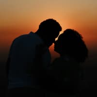 Paar küsst sich vor Sonneuntergang