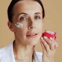 Frau hält Gesichtscreme