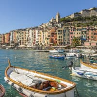 In Portovenere kannst du viele bunte Häuser finden. Ein Blick auf bunte Häuser und den Hafen von Portovenere mit kleinen Fischerbooten.