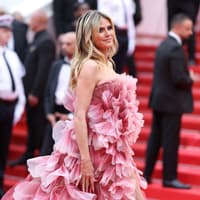 Heidi Klum auf dem roten Teppich in einem floralen Kleid in Rosa mit Blütenblättern.