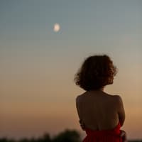 Frau schaut in Abendhimmel