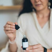 Frau öffnet Hautpflege-Serum