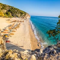 Ein Strand in Himare in Albanien mit türkisblauem Wasser und rauer Natur.