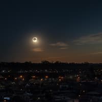 Totale Sonnenfinsternis über den Dächern einer Stadt.