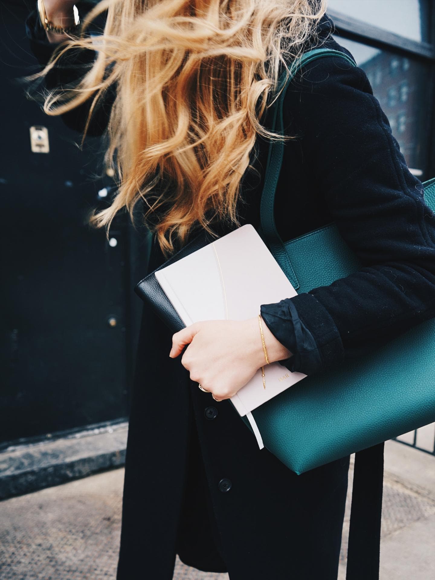 Frau trägt Notizbuch in der hand Tasche blonde Haare