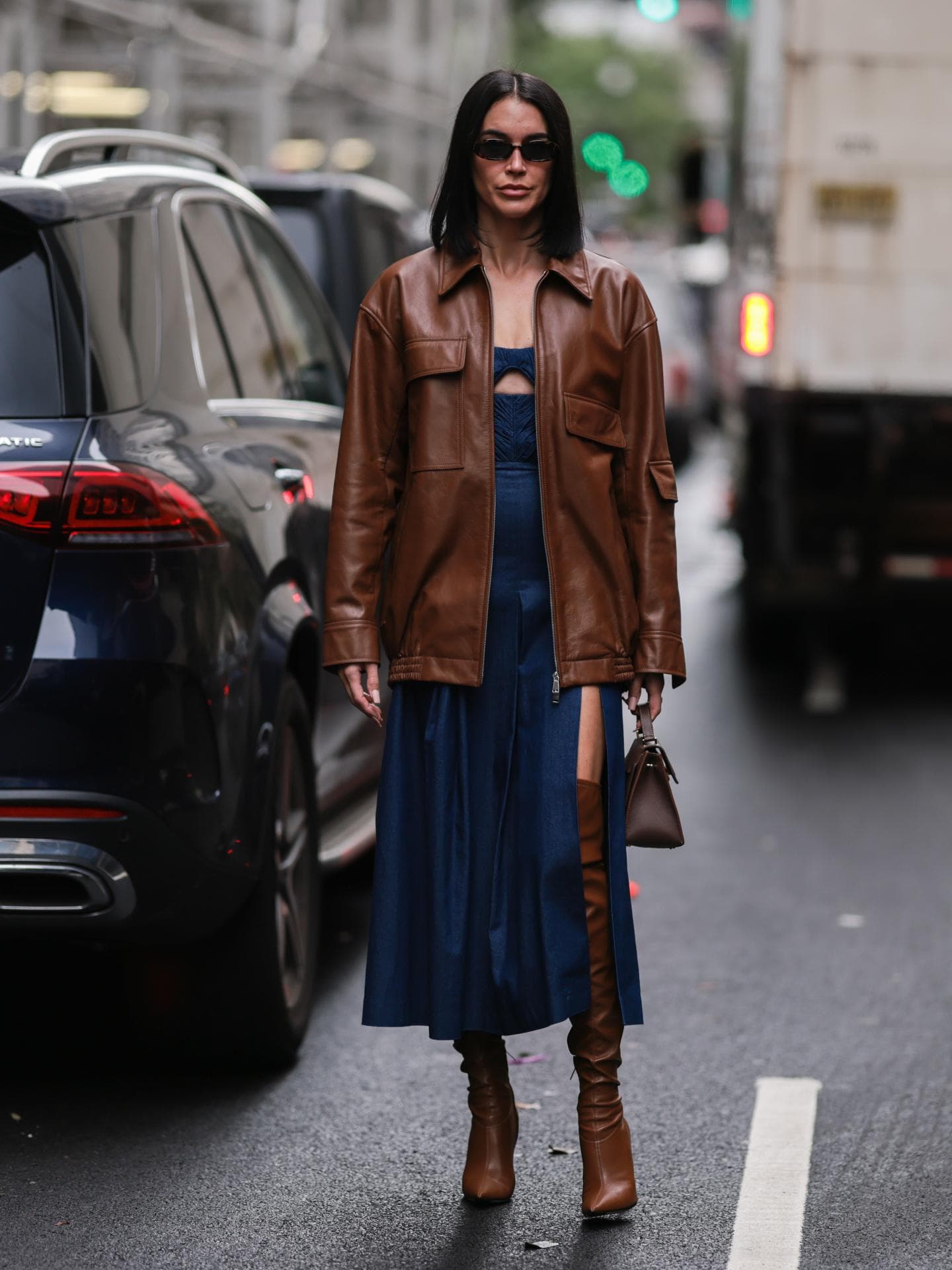 Frau in dunkelblauem Kleid mit Lederjacke
