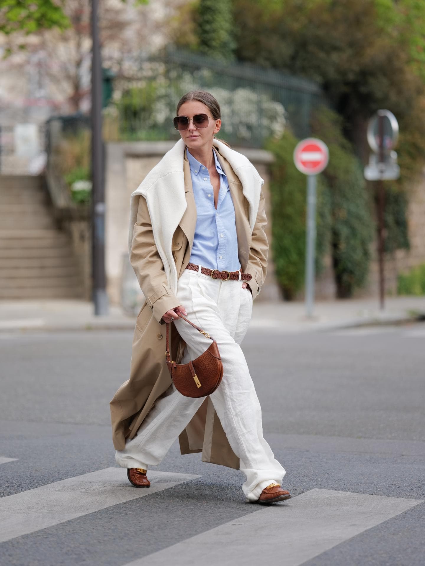 Eine Frau trägt einen Trenchcoat und Loafer