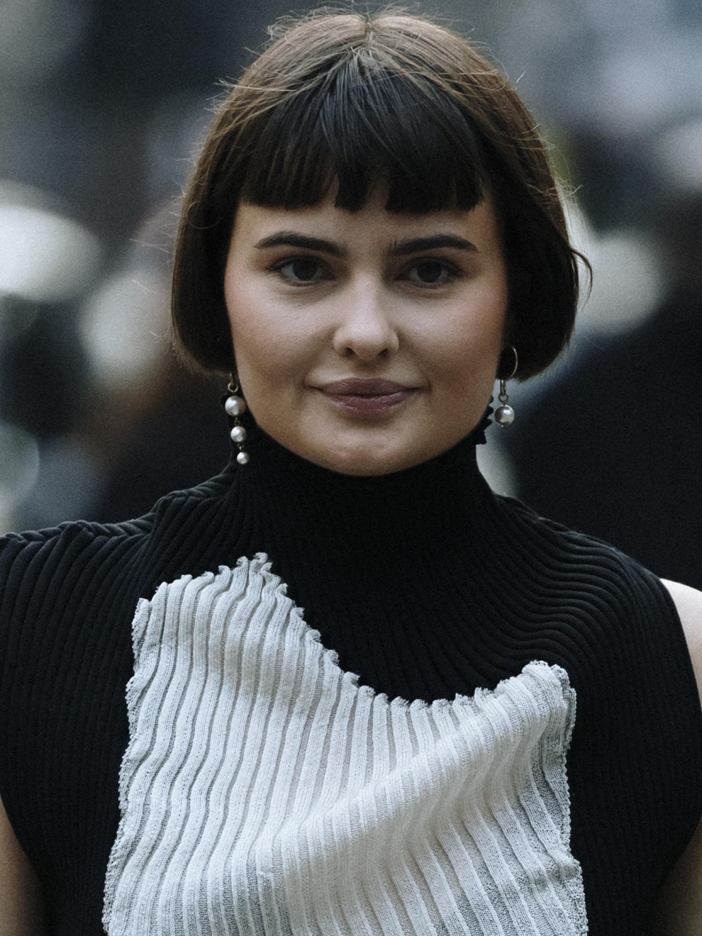 Frau auf London Fashion Week 2023 mit Stricktop und Rollkragen in Schwarz-weiß French Bob