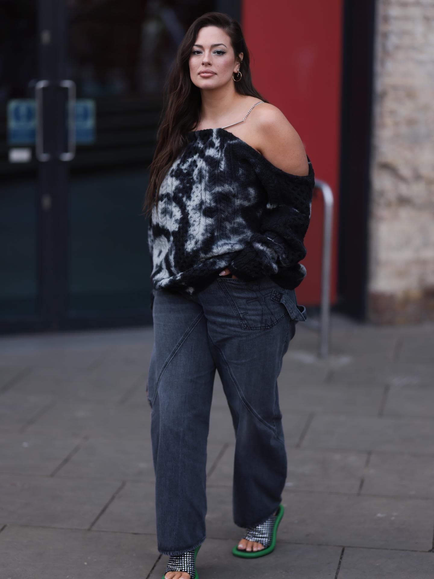 Ashley Graham trägt Off Shoulder Pullover mit grauer Jeans und High Heels