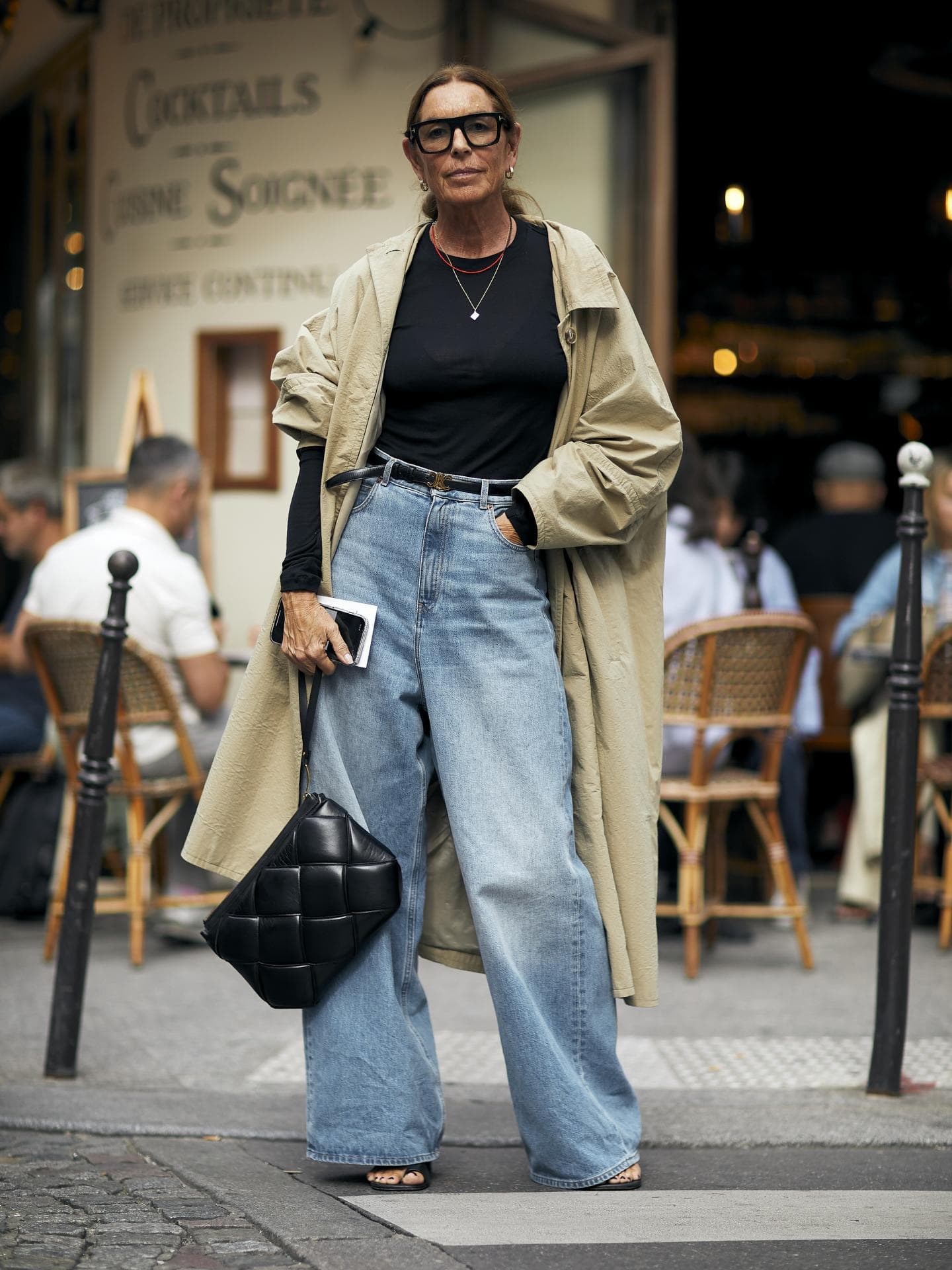 Frau trägt weite blaue Jeans mit schwarzem Blazer und Sonnenbrille sowie Jeans Top