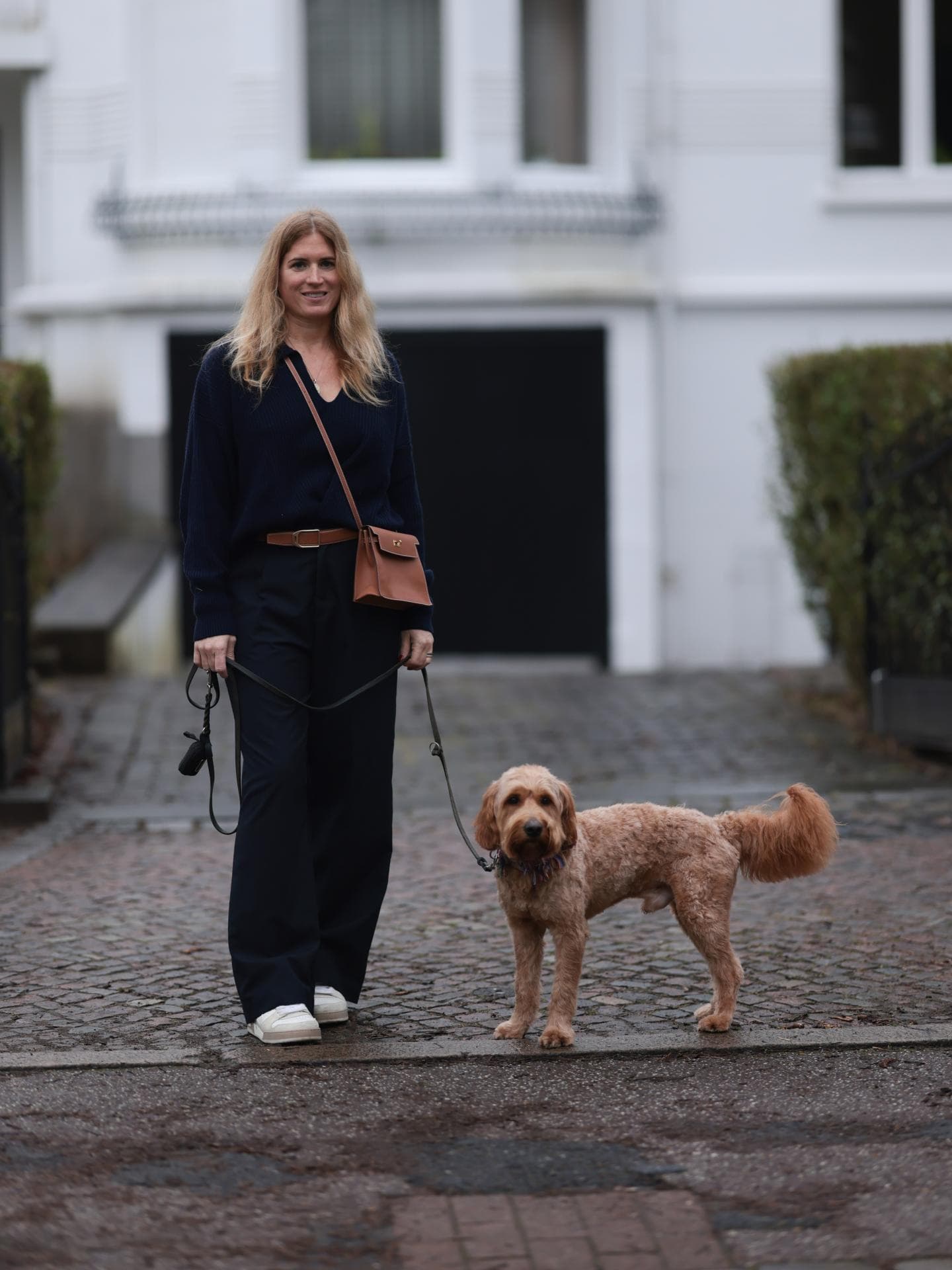 Frau mit weißen Sneakern und Hund