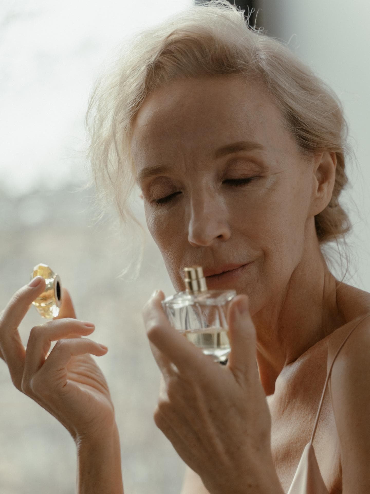 Frau riecht an Parfum