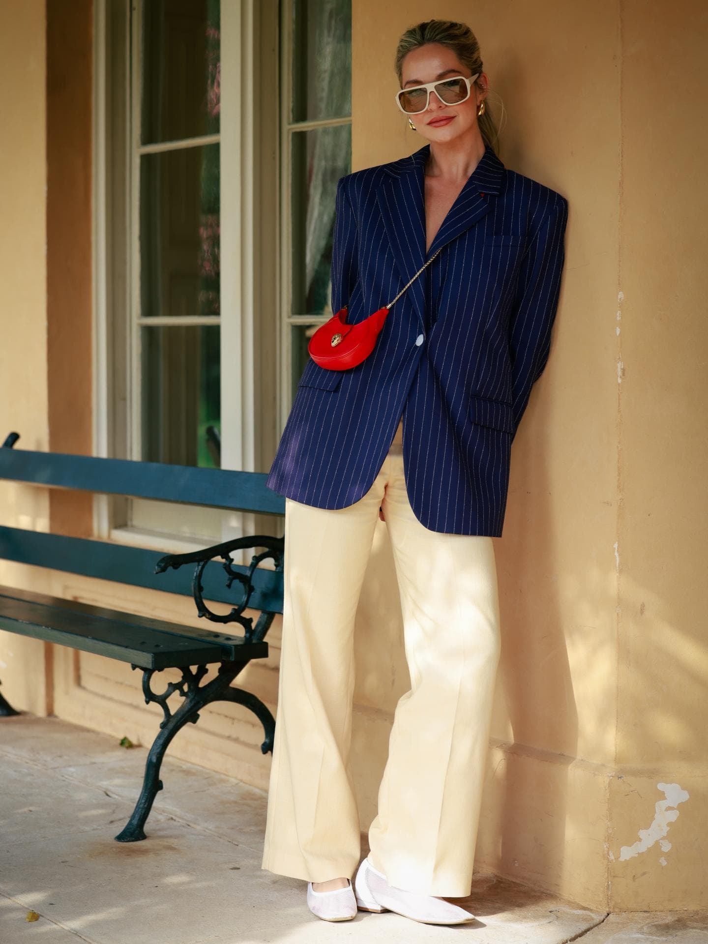 Blauer Blazer kombinieren: Styling-Tipps Frau trägt blauen Blazer und rote Tasche