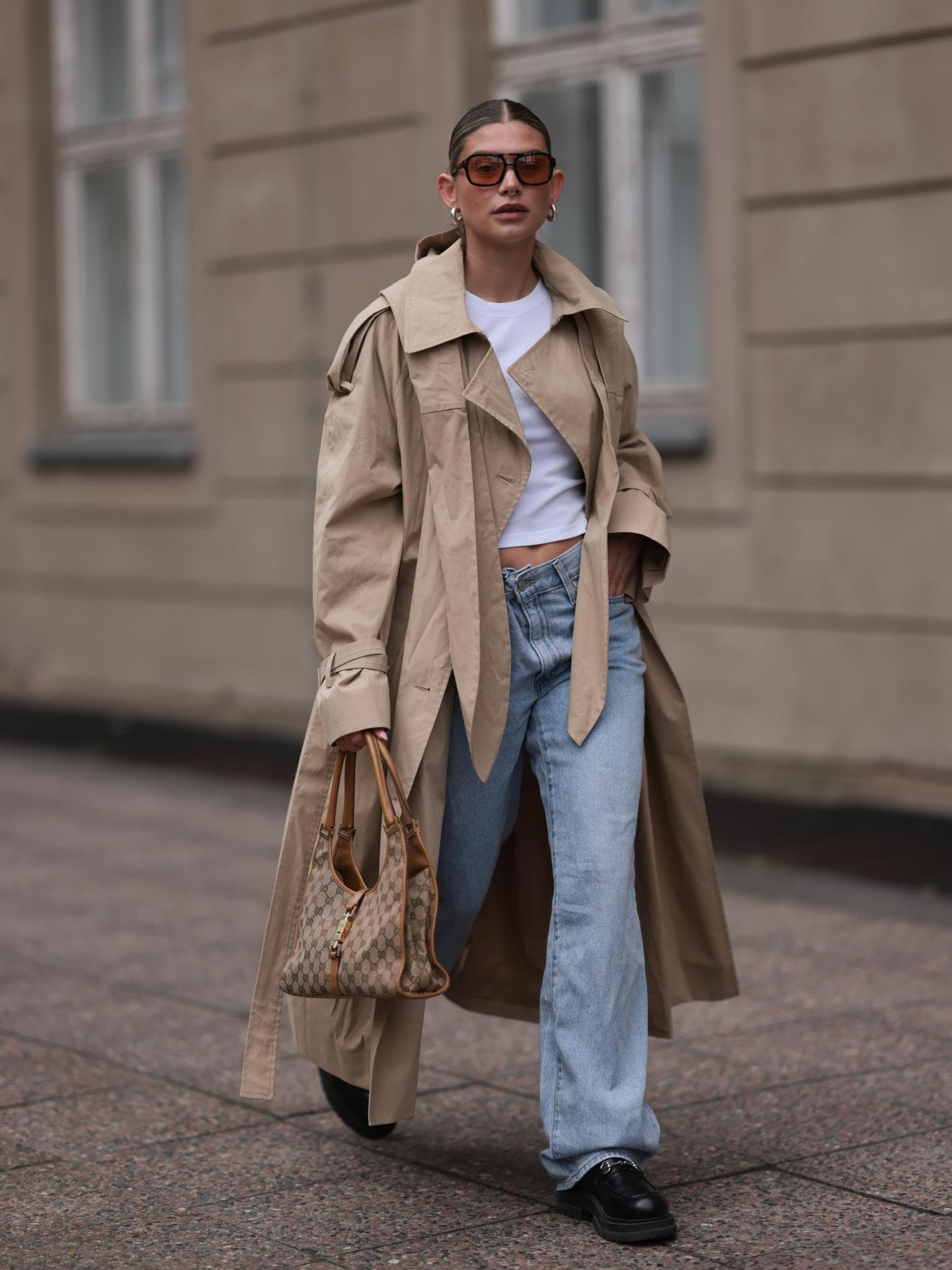 Frau in einem Trenchcoat mit Jeans