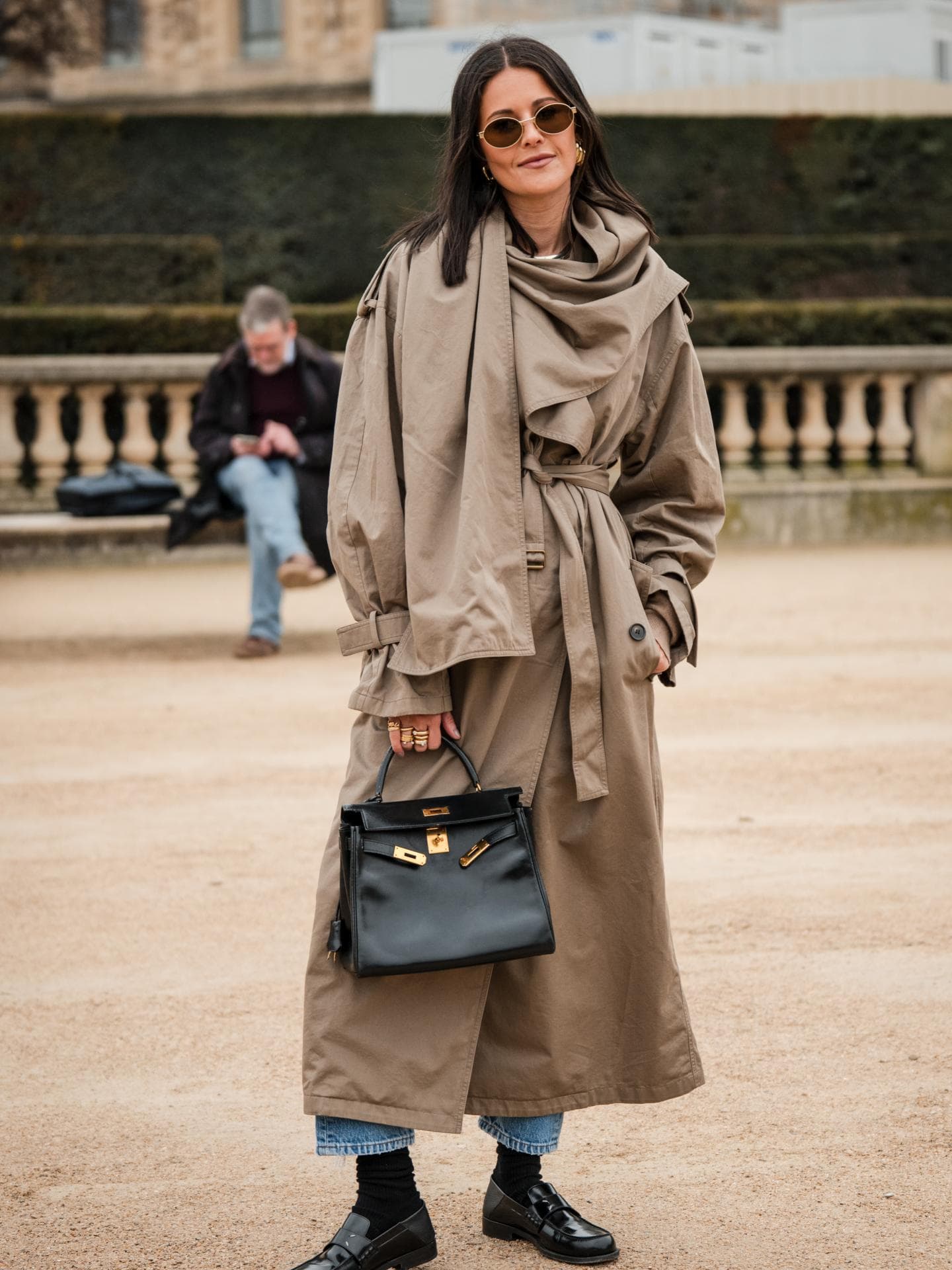 Frau trägt Loafer mit einem Trenchcoat