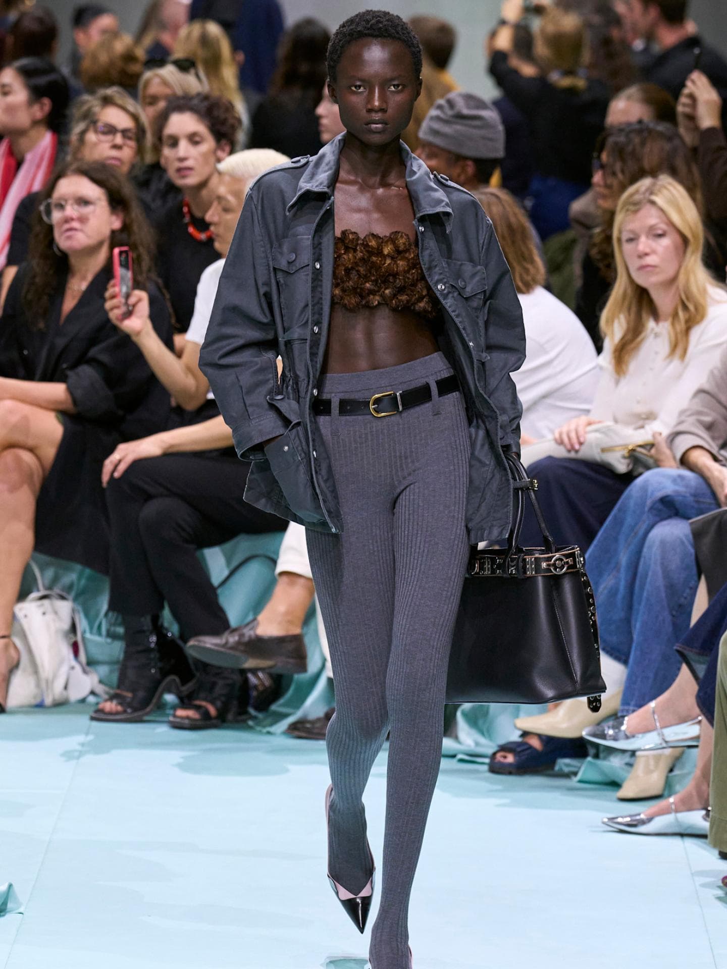 Eine lange Unterhose kann lässig mit einer Jacke kombiniert werden. Frau trägt eine lange Unterhose mit einem Gürtel und einer Jacke.