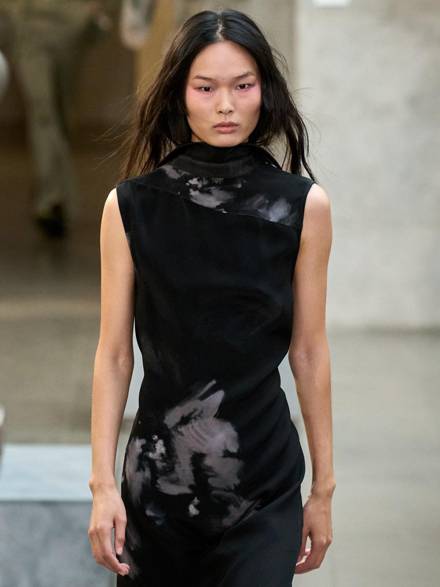 Model mit schwarzem Kleid auf dem Laufsteg