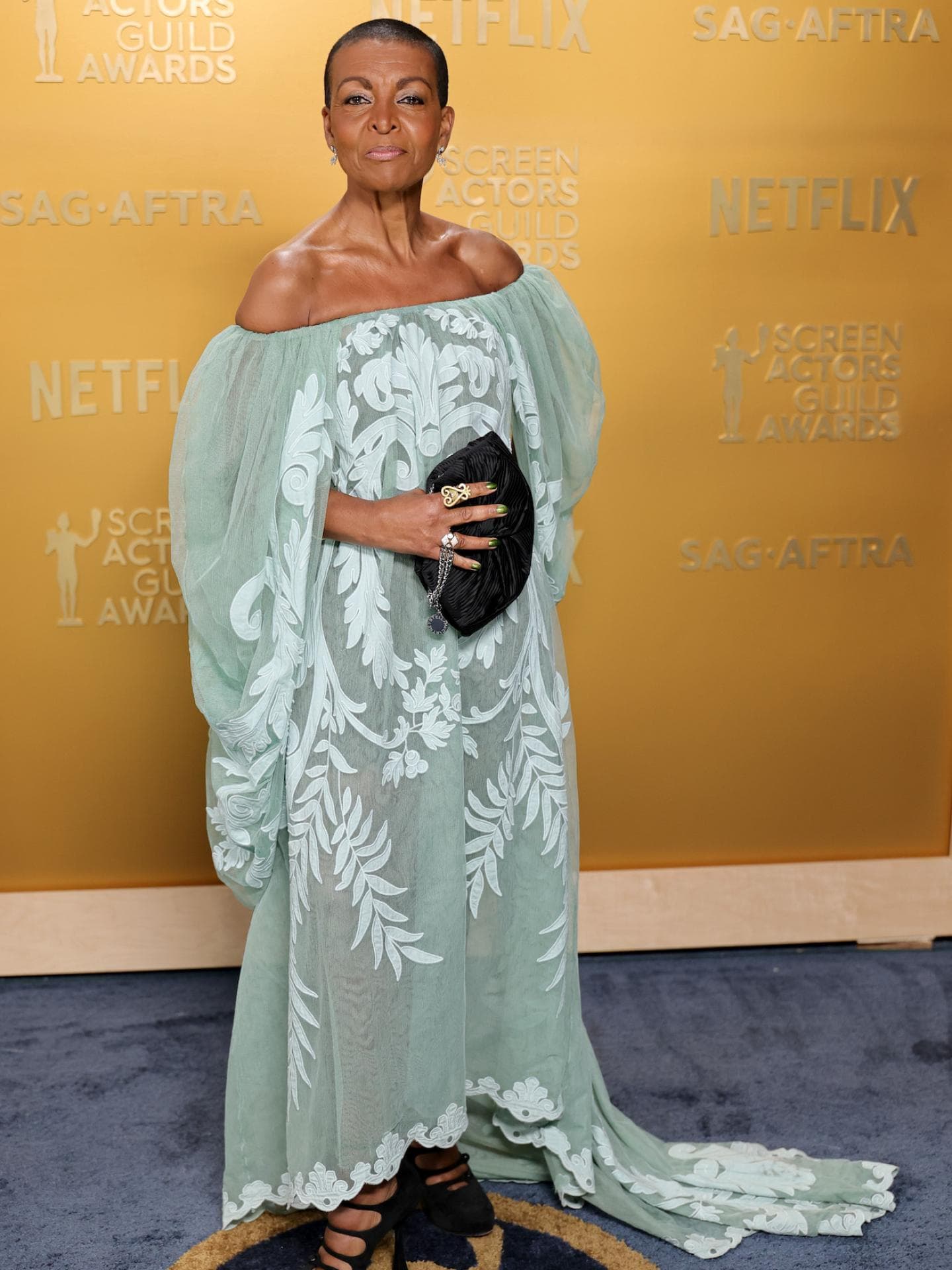 Adjoa Andoh in einem pastellgrünen Kleid mit weiten Ärmeln.