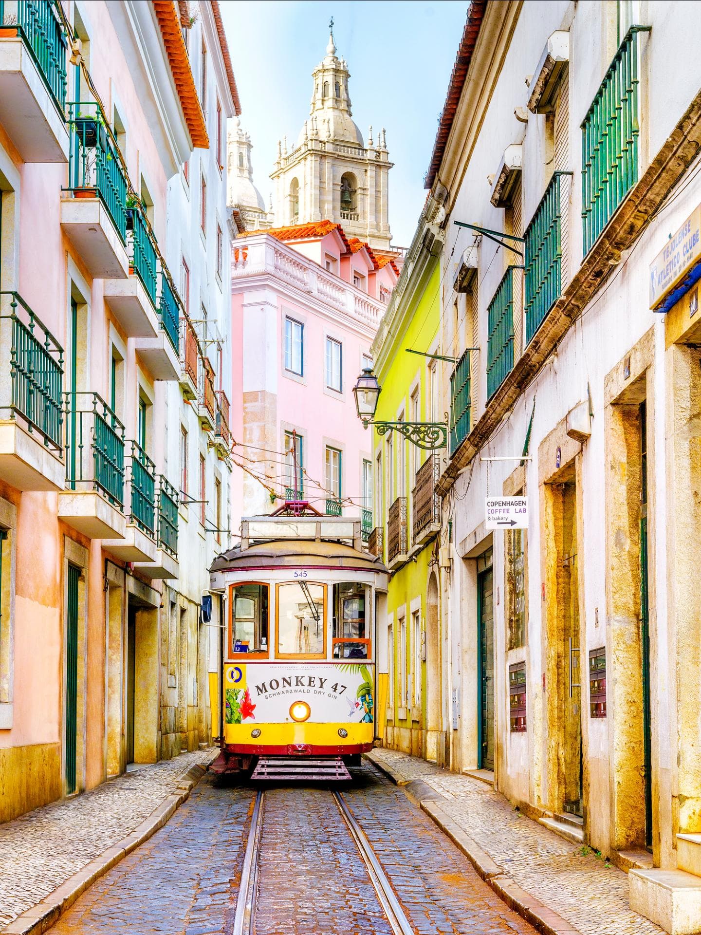 Eine typische gelbe Tram in einer engen Gasse in Alfama.
