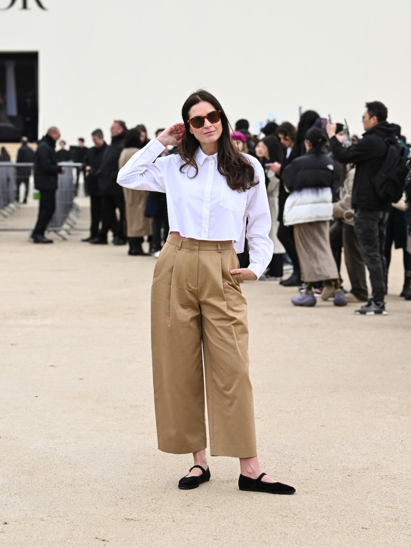Culotte-Hosen sind perfekt fürs Büro. Frau mit braunen Haaren und Sonnenbrille trägt eine weiße kurze Bluse und eine beige Culotte.