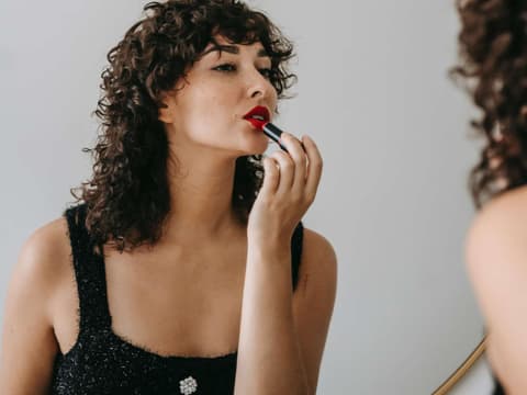 Diese 12 Dinge machen Männer heiß. Frau trägt roten Lippenstift auf.