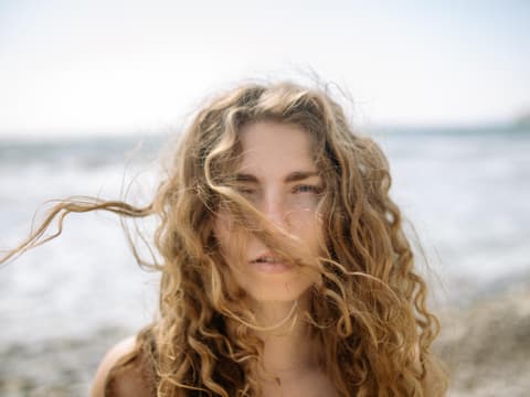 Frau mit Locken und fliegenden Haaren