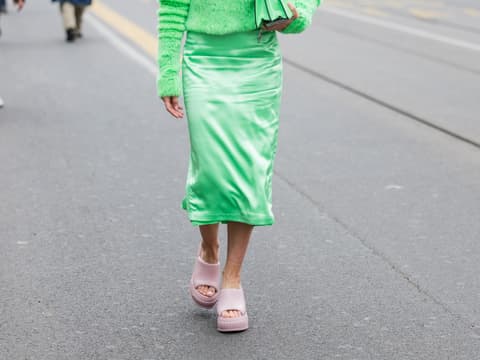 Frau mit grünem Rock und Pullover und rosa Sandalen