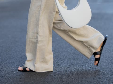 Statt Sneaker: Diese schwarzen Sandalen sind im Sommer 2023 unsere stylischen Allrounder Frau trägt schwarze Sandalen