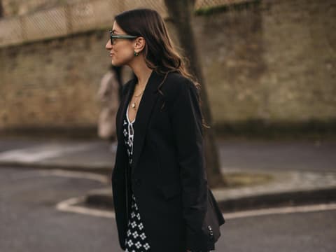 Eine Frau trägt ein langes Kleid und einen Blazer