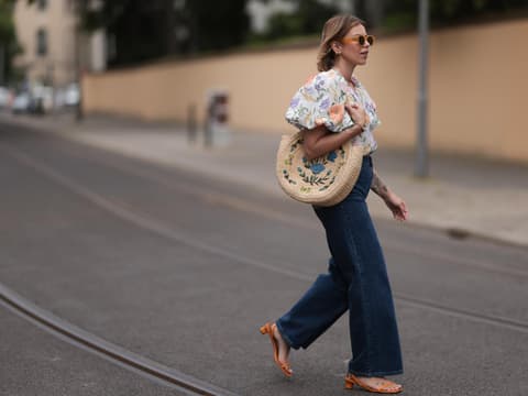 Diese 3 offenen Schuhe passen am besten zur Jeans Frau trägt eine Blümchen-Bluse und Jeans