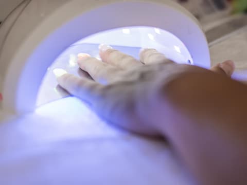 Frau haelt Hand unter UV-Licht