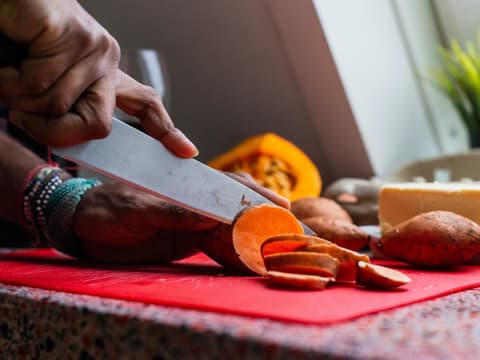 Frau schneidet Süßkartoffeln