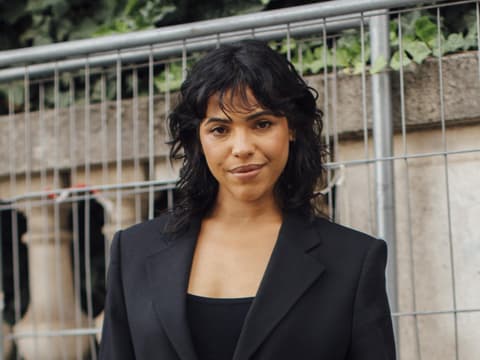 Paris Streetstyle Frau trägt angesagten Look und Locken im Haar plus pony